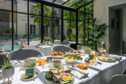 une table avec des plats de nourriture dessus dans l'établissement Villa Grand Voile - Christopher Coutanceau, à La Rochelle
