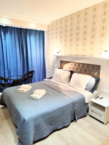 a bedroom with a large bed with two towels on it at Batumi - Premium Studio in Batumi
