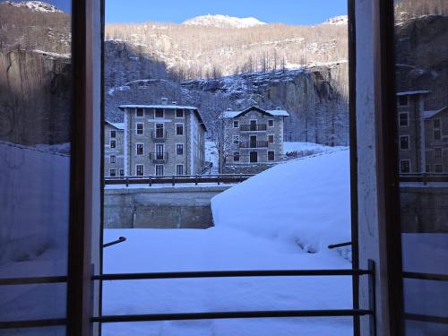 a view from a window covered in snow at Grand Hotel Ceresole Reale studio apartment in Ceresole Reale
