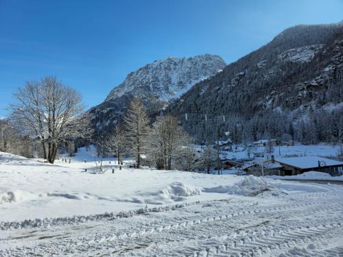 a snow covered field with a mountain in the background at Grand Hotel Ceresole Reale studio apartment in Ceresole Reale