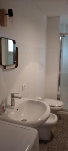 biała łazienka z umywalką i toaletą w obiekcie Da Apollonio w mieście Nuoro