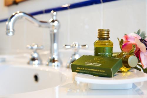 a bottle of essential oil sitting on a bathroom sink at Cortona Resort-Le Terre Dei Cavalieri in Cortona