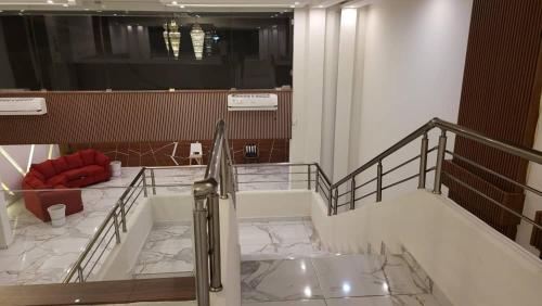 a lobby with a staircase with a glass railing at LIA hotel- Lungi International Airport in Tulun
