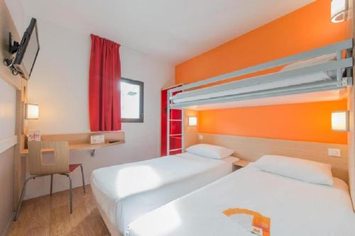 a hotel room with two beds and a desk at Premiere Classe Vichy - Bellerive Sur Allier in Bellerive-sur-Allier