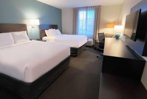 a hotel room with two beds and a desk at La Quinta Inn & Suites by Wyndham Wenatchee in Wenatchee