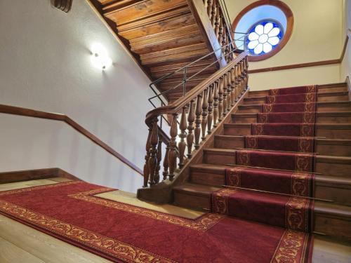 a staircase in a house with a red rug at Grand Hotel Ceresole Reale Bill Apartment in Ceresole Reale