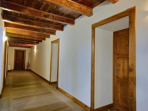 an empty hallway with wooden ceilings and a door at Grand Hotel Ceresole Reale Bill Apartment in Ceresole Reale