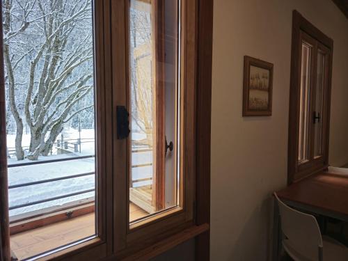 a window with a view of a snow covered yard at Grand Hotel Ceresole Reale Bill Apartment in Ceresole Reale