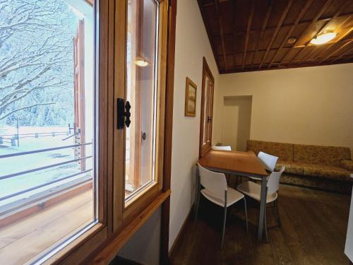 a room with a table and chairs and a window at Grand Hotel Ceresole Reale Bill Apartment in Ceresole Reale