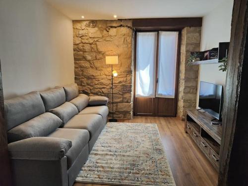 a living room with a couch and a television at Kareharri Piso en Casco Viejo de Zarautz in Zarautz