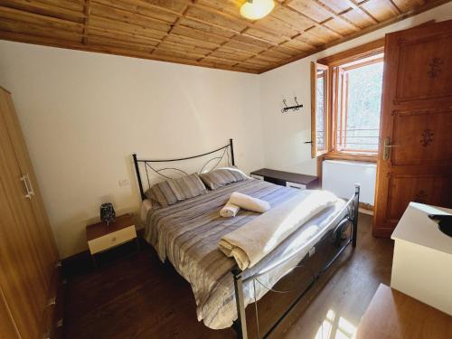 a bedroom with a large bed with a wooden ceiling at Grand Hotel Ceresole Reale Bill Apartment in Ceresole Reale