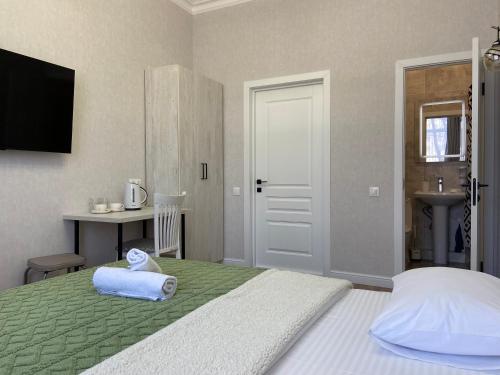 a bedroom with a bed with a towel on it at Rose Art hotel in Astana