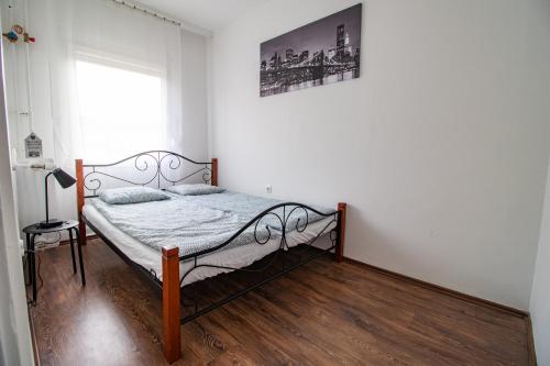 um quarto com uma cama num quarto com uma janela em LénApartman - Dakota em Pécs