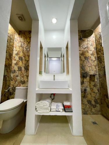 a bathroom with a toilet and a sink at Montani Beach Resort Puerto Galera powered by Cocotel in Puerto Galera