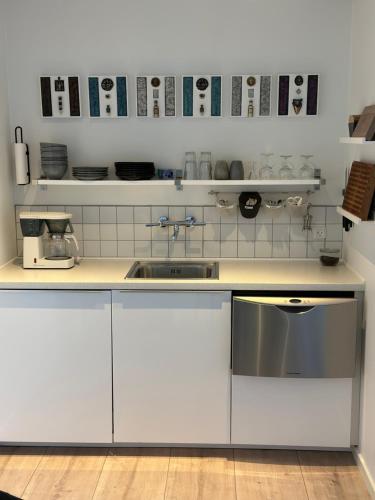 eine Küche mit weißen Schränken und einem Waschbecken in der Unterkunft Lucky 3 Apartments in Løkken