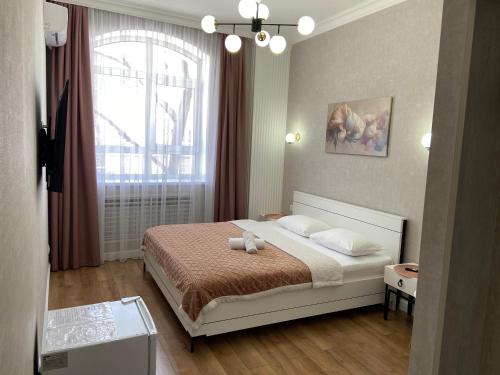 1 dormitorio con cama y ventana en Rose Art hotel, en Astana