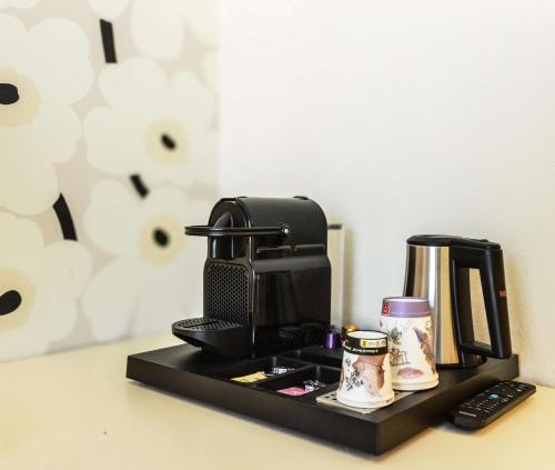 a black coffee maker on a black tray on a counter at Best Western Gemenos en Provence in Gémenos