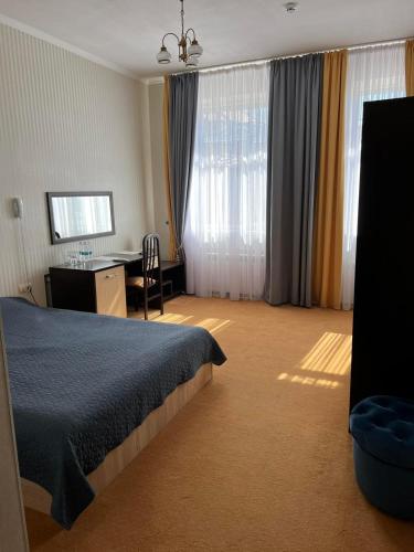 a bedroom with a bed and a desk with a chair at In hotel in Kamianets-Podilskyi