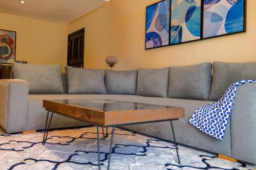uma sala de estar com um sofá e uma mesa de centro em Blue Note - Marina Agadir - Piscine - 4 or 5 Px em Agadir