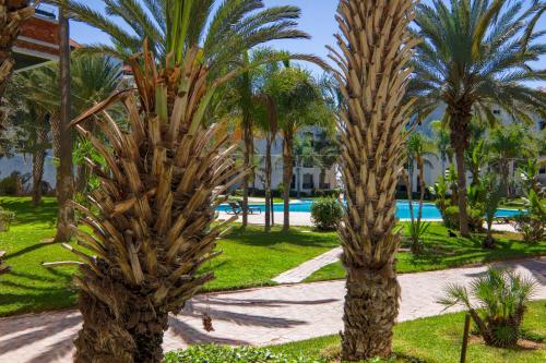 duas palmeiras num parque com piscina em Blue Note - Marina Agadir - Piscine - 4 or 5 Px em Agadir