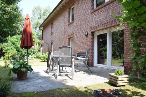 a patio with a table and an umbrella at Ferienwohnung Eulenhof in Templin