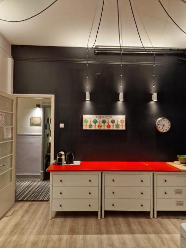 una cocina con encimera roja contra una pared negra en Castilho 63 Hostel & Suites, en Lisboa