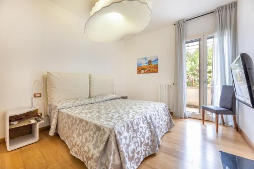 Schlafzimmer mit einem Bett, einem TV und einem Fenster in der Unterkunft Quadrilocale Corso Italia 29 piano terra con spazio esterno in Gallipoli