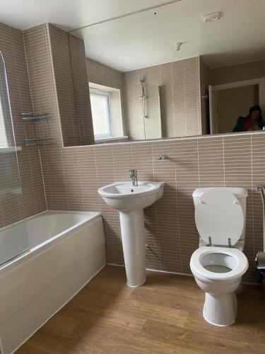 a bathroom with a toilet and a sink and a tub at Highly Comfortable Home in Hatfield