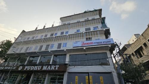 un edificio alto con un cartel encima en MR.WHITE PRIME RESIDENCY en Chennai