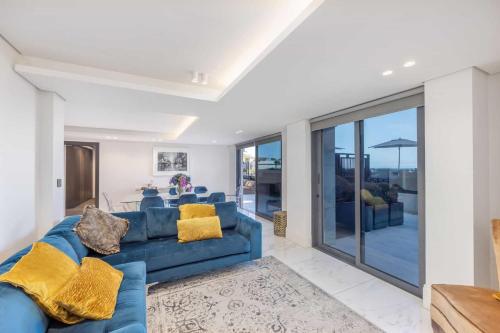 sala de estar con sofá azul y almohadas amarillas en 102 Aurum Residences by Totalstay en Ciudad del Cabo