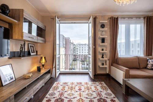 uma sala de estar com um sofá e uma grande janela em 27 Gdynia Centrum - Apartament Mieszkanie dla 2 os em Gdynia