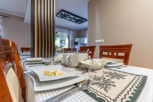 a dining room table with a plate of food on it at Leśny Dworek Biały Dunajec in Zakopane