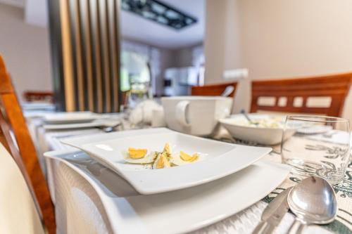 a table with a white plate on top of it at Leśny Dworek Biały Dunajec in Zakopane