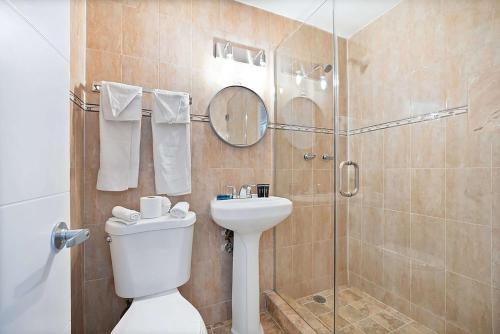 een badkamer met een douche, een toilet en een wastafel bij Garden Hotel Miami Airport, Trademark Collection by Wyndham in Miami