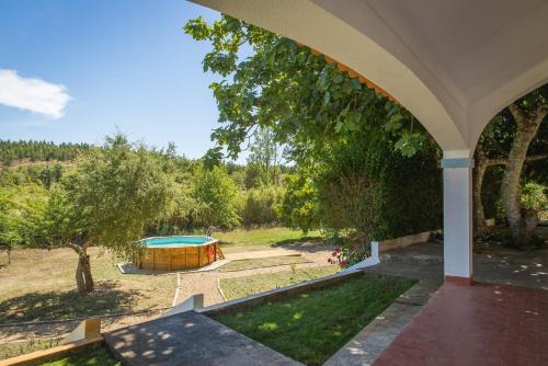 une arche d'une maison avec une piscine dans une cour dans l'établissement Quinta do Marmeleiro - Casa Marmeleiro, à Santiago do Cacém