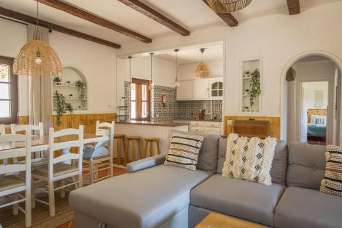a living room and kitchen with a couch and a table at Quinta do Marmeleiro - Casa Marmeleiro in Santiago do Cacém