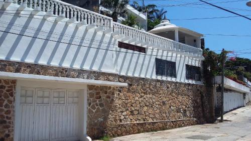 a white roofed house with a white garage at Villa Costa Chica Comodisimo piscina gigante jardines in Acapulco