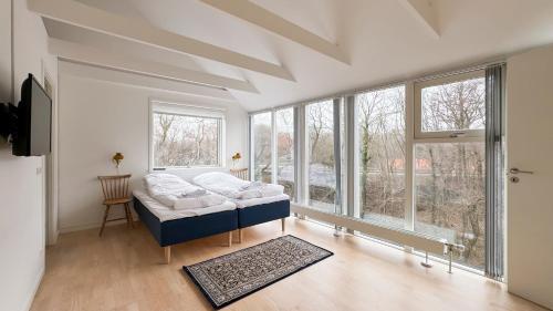 sala de estar con cama y ventanas grandes en Hotel Aahøj, en Saeby