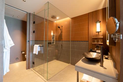 uma casa de banho com um chuveiro e um lavatório. em Centara Grand Mirage Beach Resort Pattaya em Pattaya North