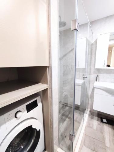 a white washing machine in a bathroom with a sink at Batumi - Premium Studio in Batumi