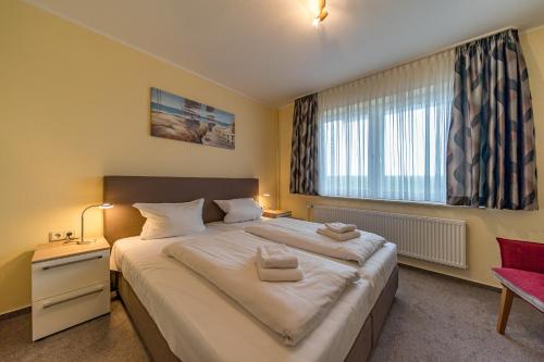 Un dormitorio con una cama grande y una ventana en Hus Strandkieker Hus Strandkieker 04, en Schillig