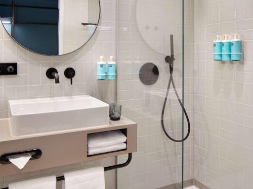 a bathroom with a sink and a shower at Novotel Hamburg Central Station in Hamburg