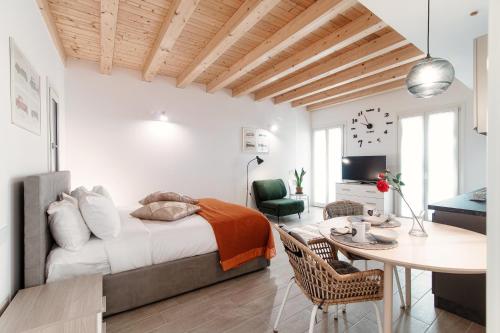 1 dormitorio con cama, mesa y comedor en Numero 11 Piazza Amendola - by MyHomeInComo, en Como