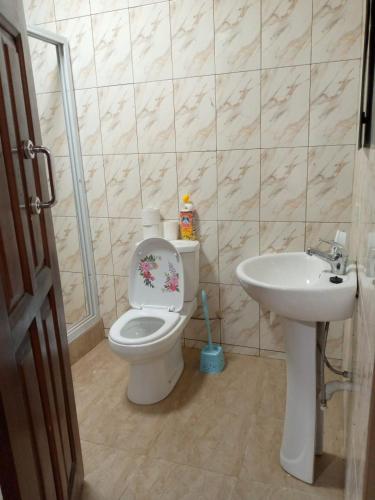 a bathroom with a toilet and a sink at SANAMOND VILLA in Dodowa