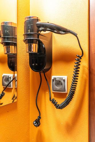 a telephone is attached to a yellow wall at Leśny Dworek Biały Dunajec in Zakopane
