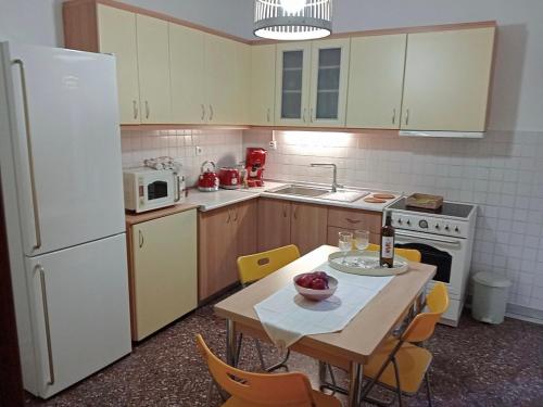 a kitchen with a table and a white refrigerator at Comfortable apartment in Thessaloniki in Thessaloniki