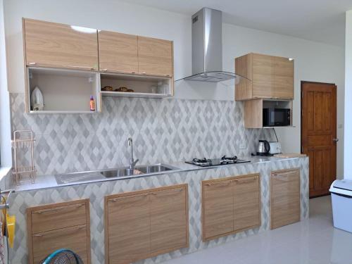 a kitchen with wooden cabinets and a counter top at Seaview Eagles Nest Apartment 2 in Rawai Beach