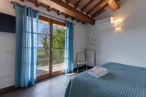 ein Schlafzimmer mit einem Bett und einer Glasschiebetür in der Unterkunft Villa Moderna Resort in Borgo San Lorenzo