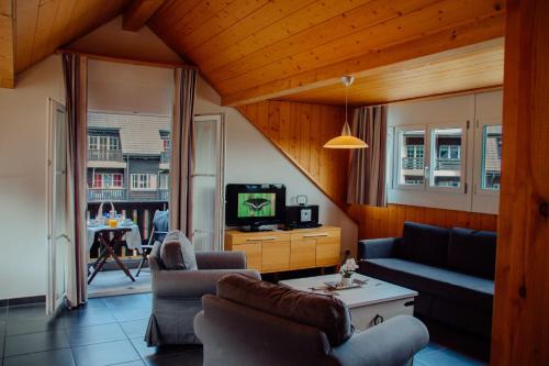 a living room with a couch and a tv at Andromède, appartements 2 à 5p de standing in Moleson