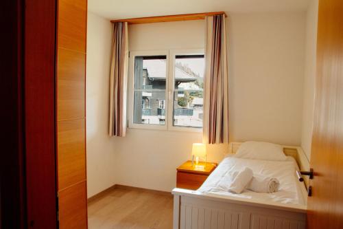 a small bedroom with a bed and a window at Andromède, appartements 2 à 5p de standing in Moleson